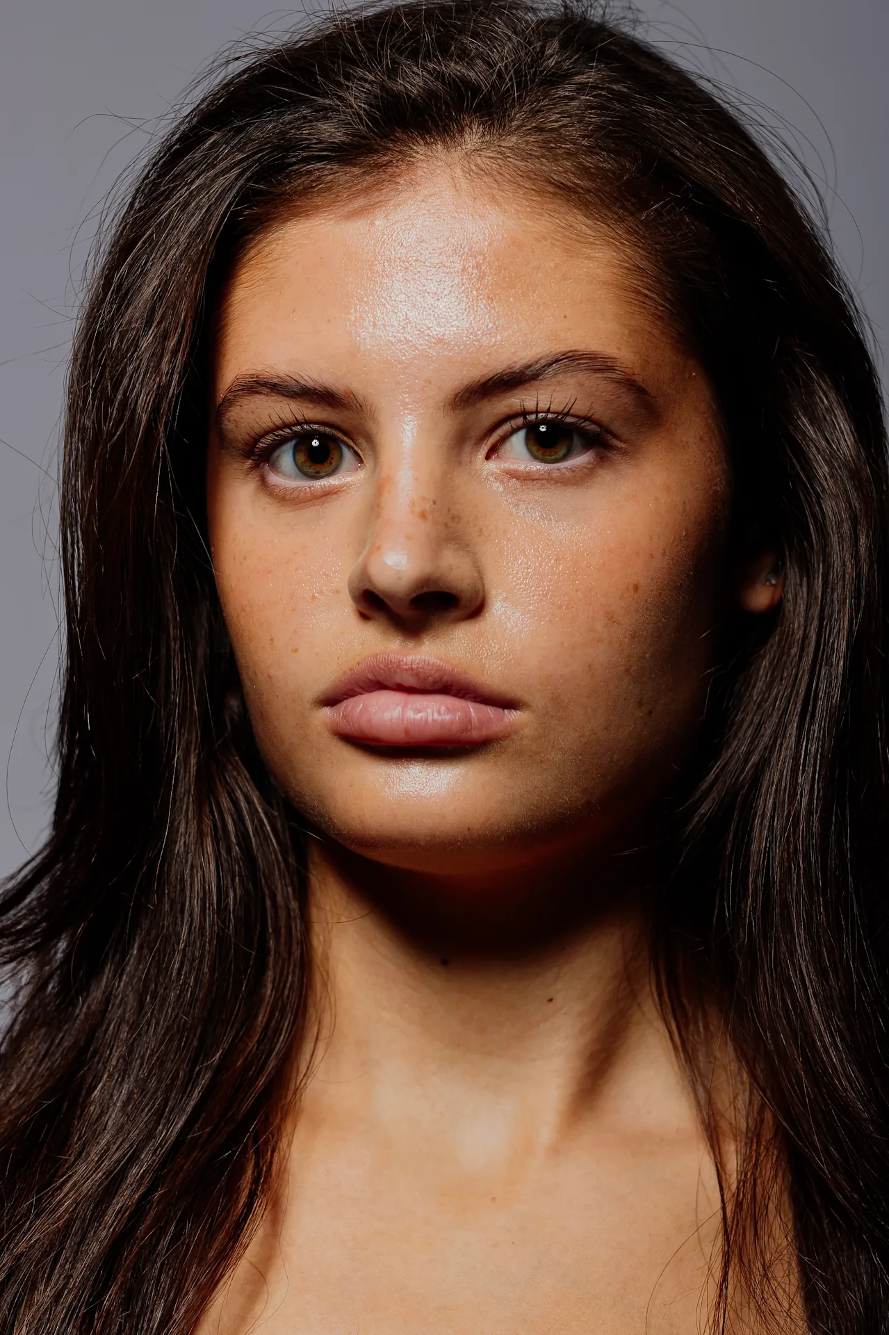Tight, head-on portrait against grey background